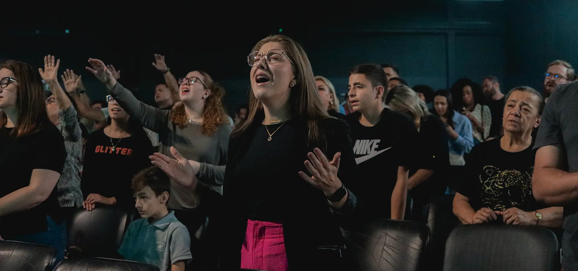 Pessoas adorando durante um culto da Alcance Pinhais
