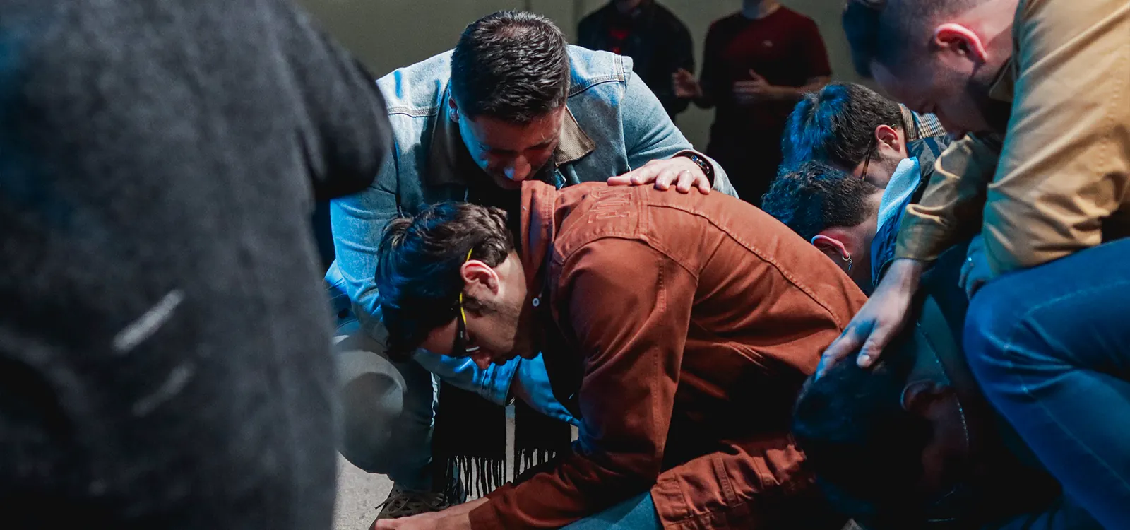 Pessoas orando juntas durante um culto da Alcance Pinhais